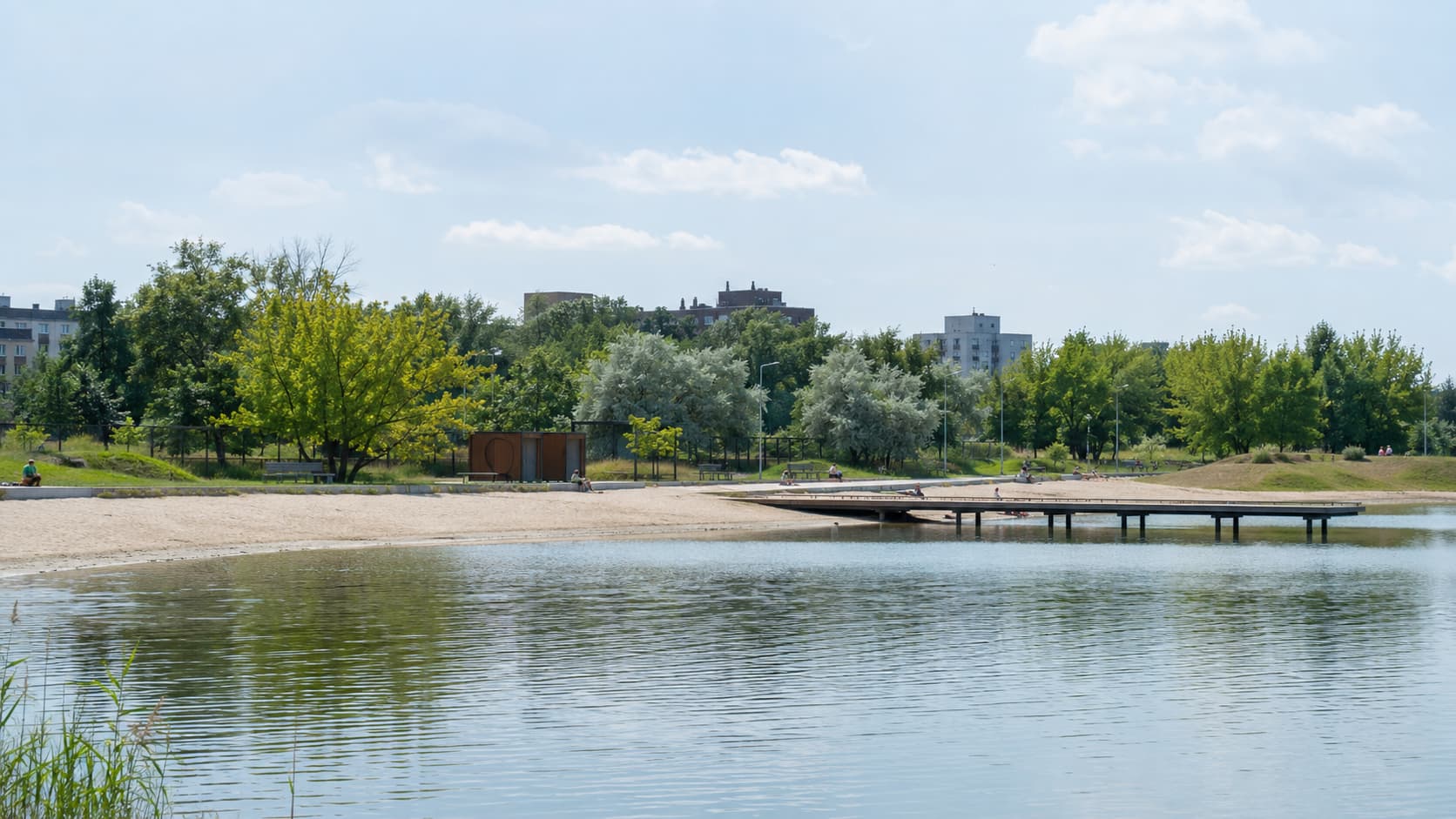 Staw Morawa w Katowicach z plażą, pomostem i zielonym brzegiem